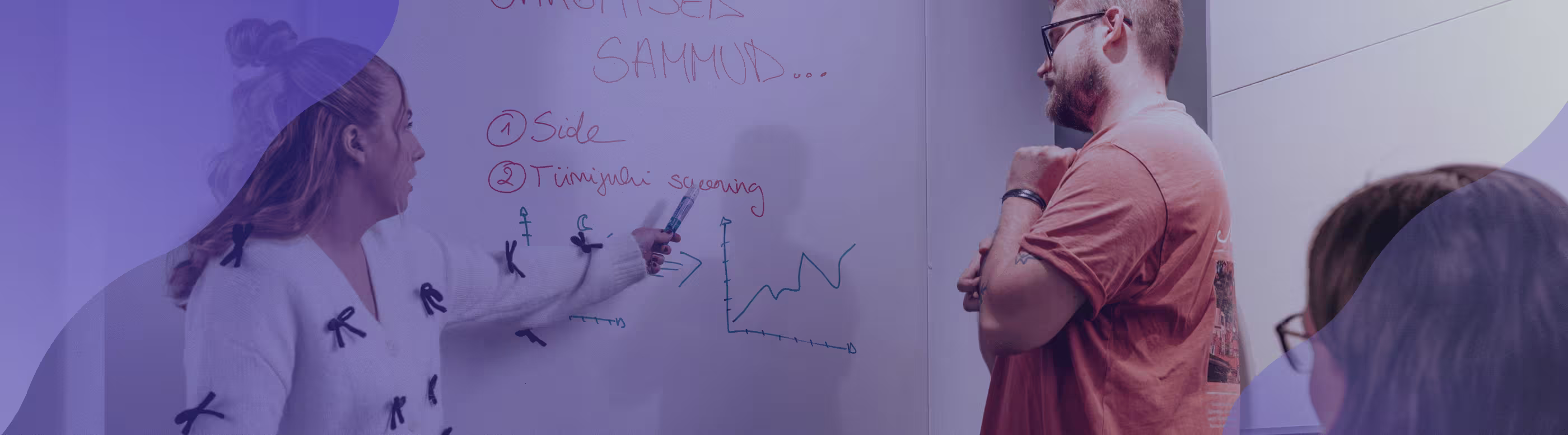 Two people writing on a whiteboard