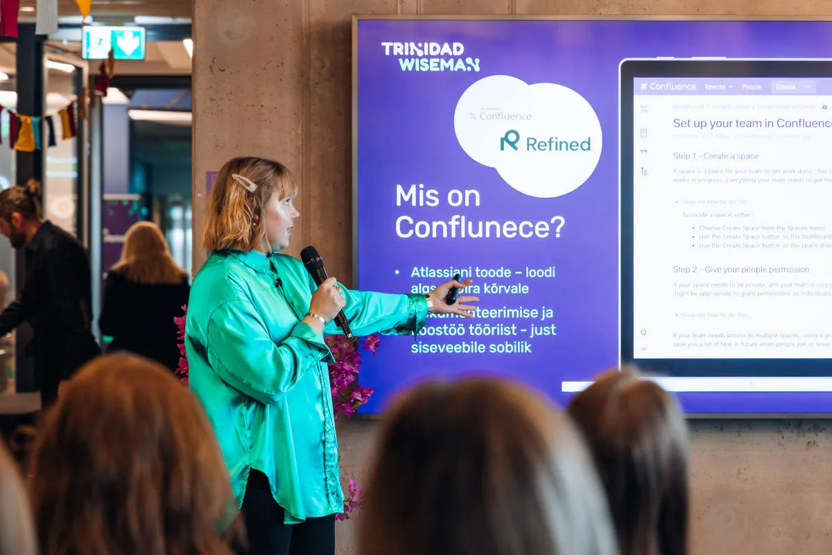 Naine näitab käega presentatsioonile
