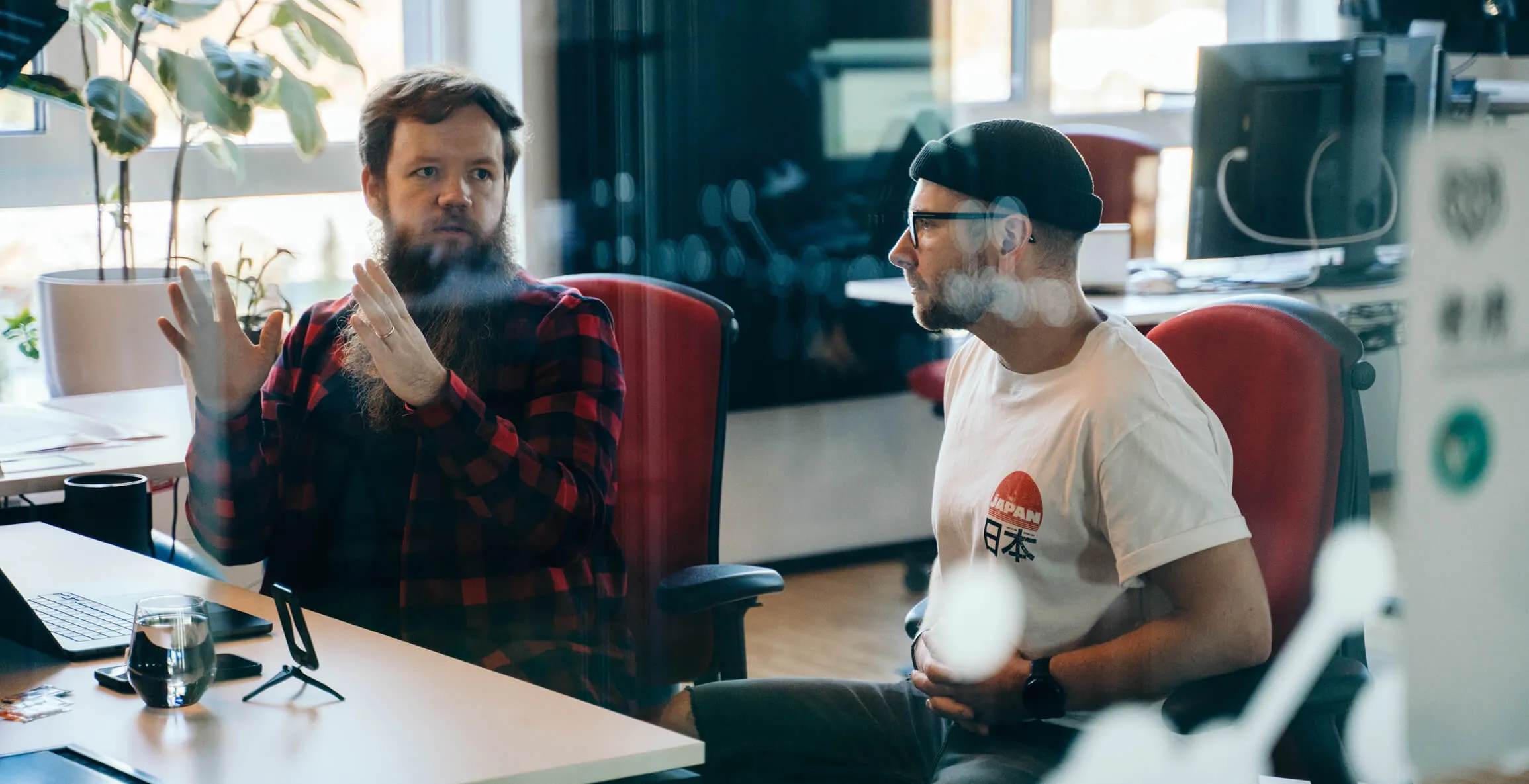 Two people discussing beside a laptop – an illustration of website accessibility and user journey assessment.