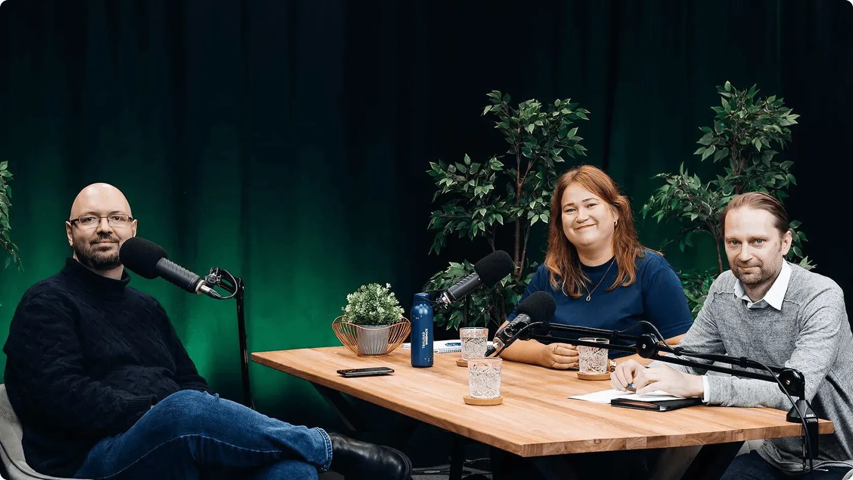 Kolm inimest istuvad laua taga 